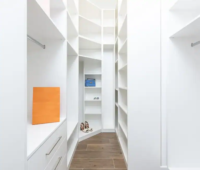 Bright white corner shelving in a closet