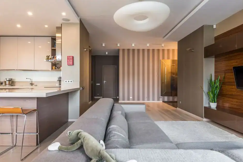 A bright, modern open-plan living room with a grey sofa
