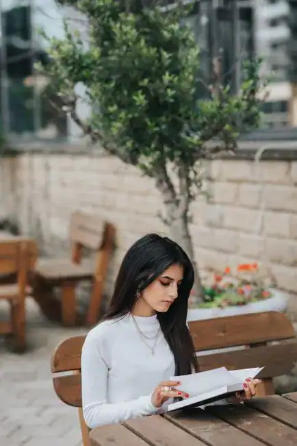 A woman reading a book at an outdoor cafe
