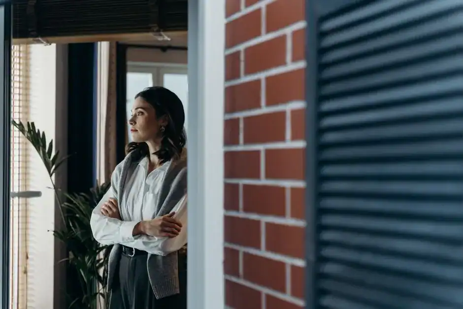 A woman pausing to reflect by a window
