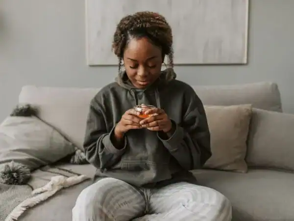 A woman relaxing on the couch with a warm drink on a hard day