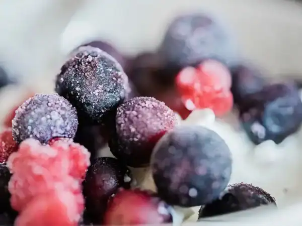 A bowl of colorful frosted frozen berries