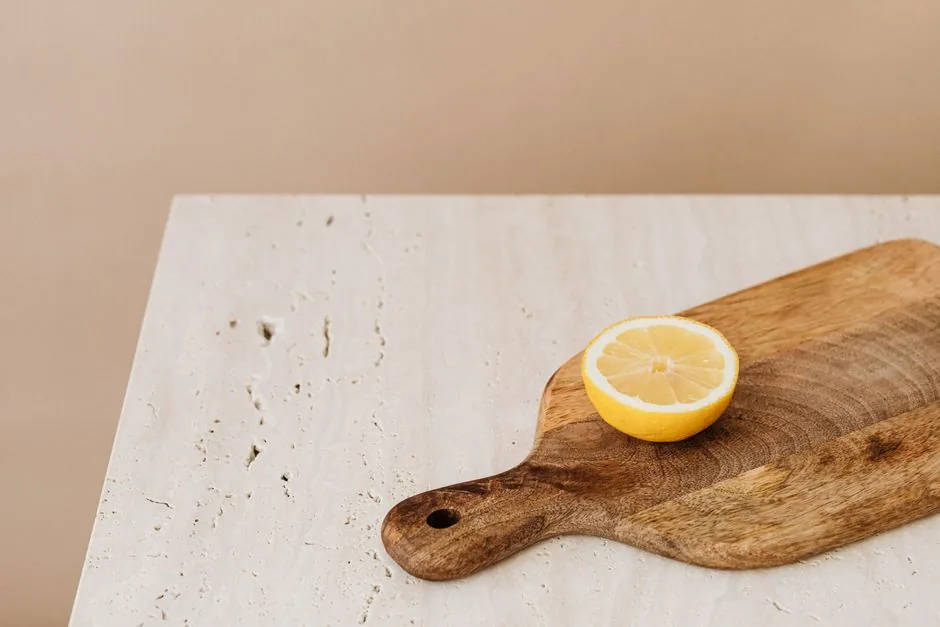 A lemon half on a wooden cutting board
