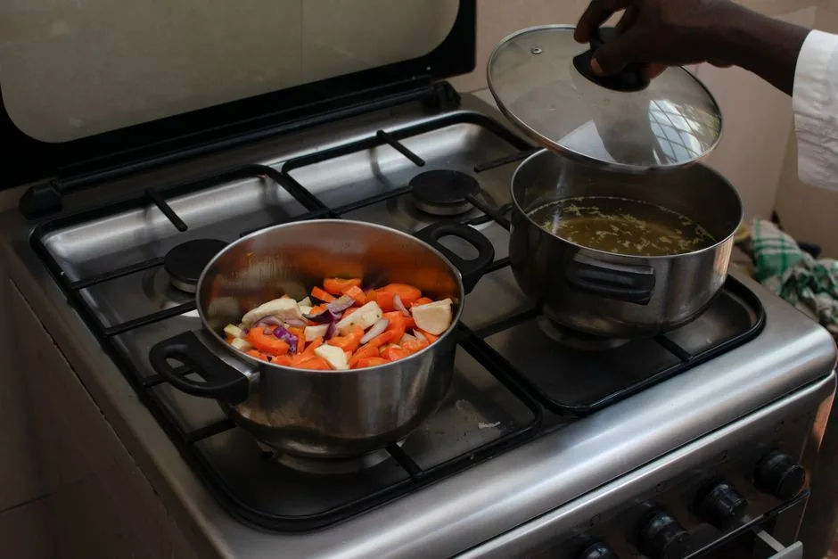 Vegetable scraps and broth simmering in pots on a home stove