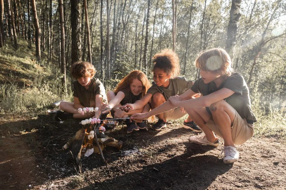 Kids roasting marshmallows together over a small campfire