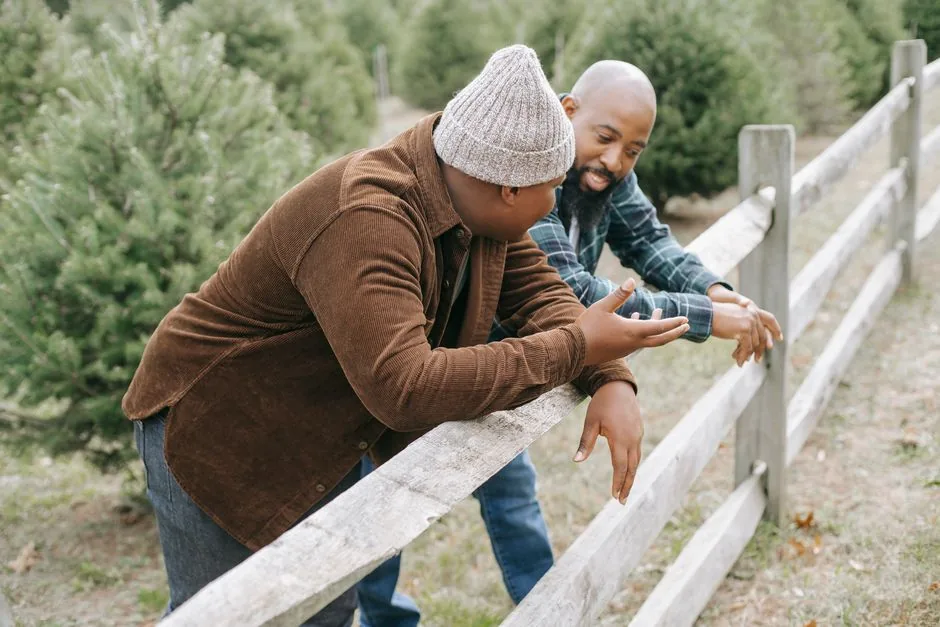 Two neighbors talking over a wooden fence