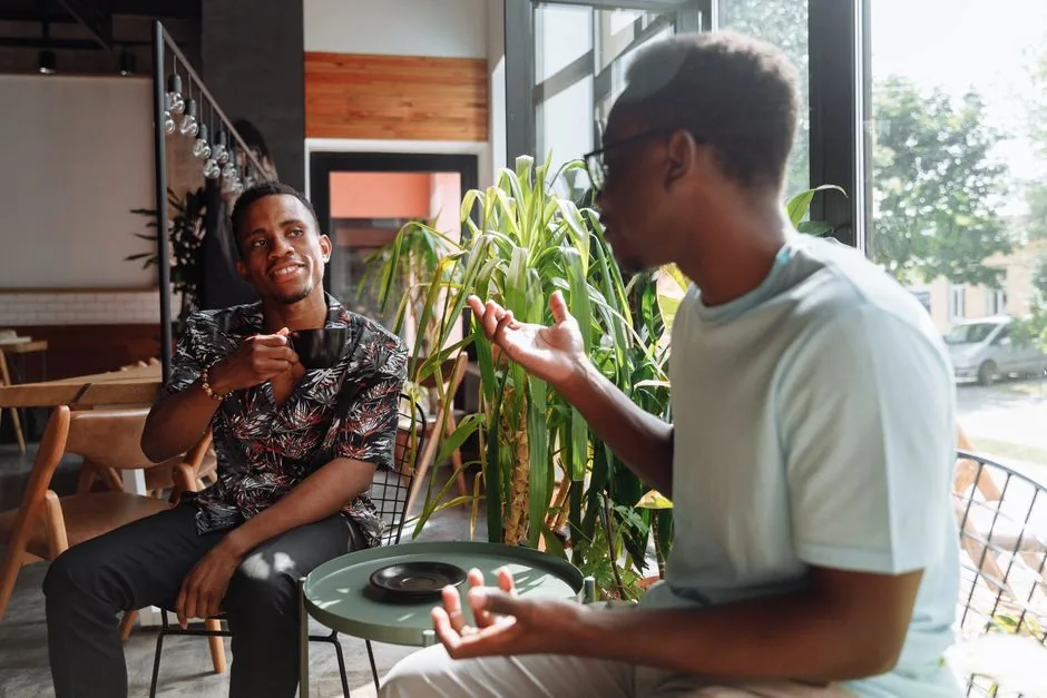 Two friends having a conversation over coffee with no phones out