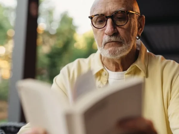 An older man absorbed in reading a paper book