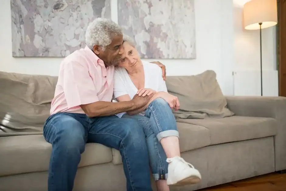 An older couple comforting each other on the couch