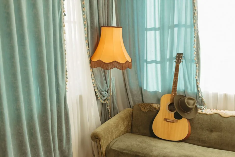 A vintage living room with a velvet sofa and a fringed lamp