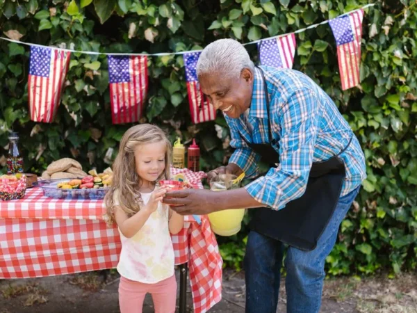 A grandfather and granddaughter at a summer table decorated with flags