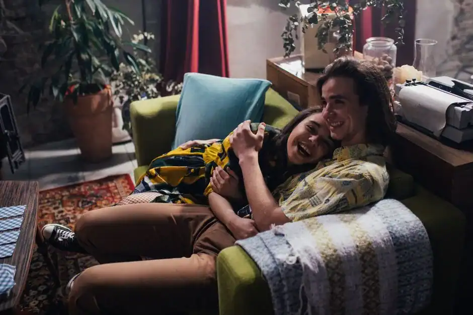 A joyful couple relaxing together on a cozy couch, enjoying each other's company.