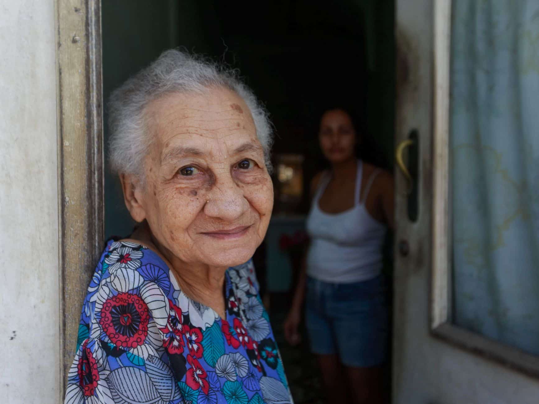 Grandmother standing in the open doorway of her home