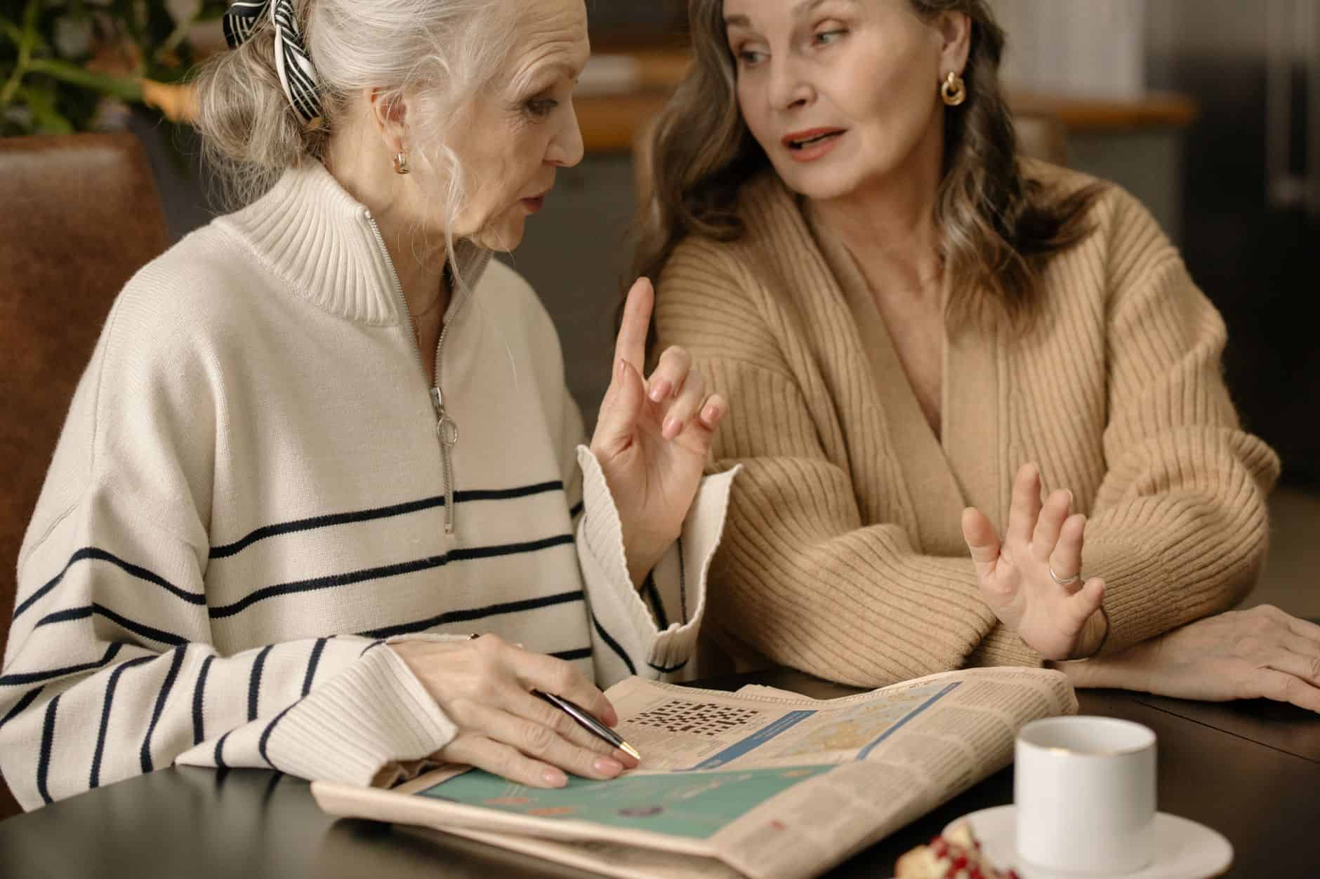 Two older women talking over coffee at the table