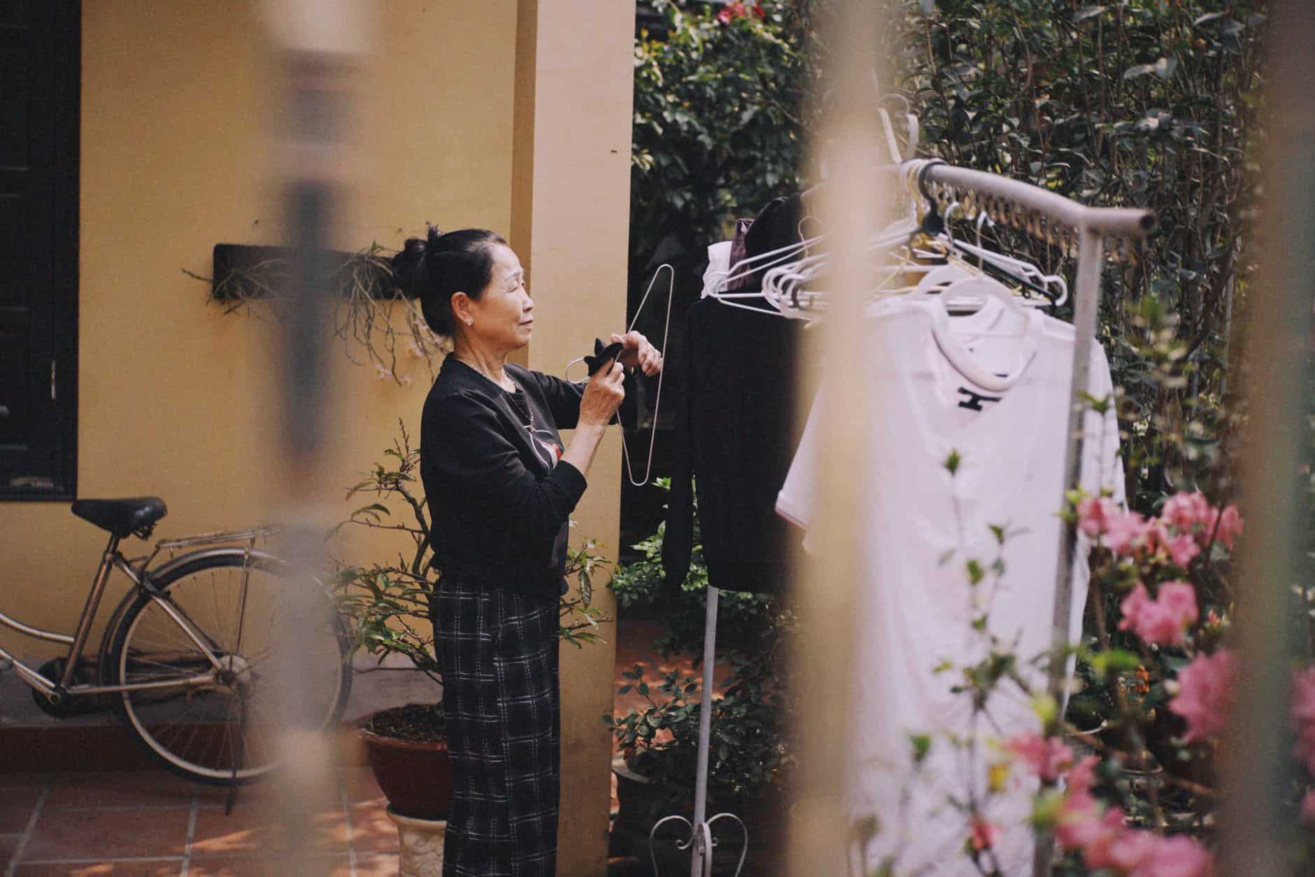 Grandmother hanging laundry to dry outdoors