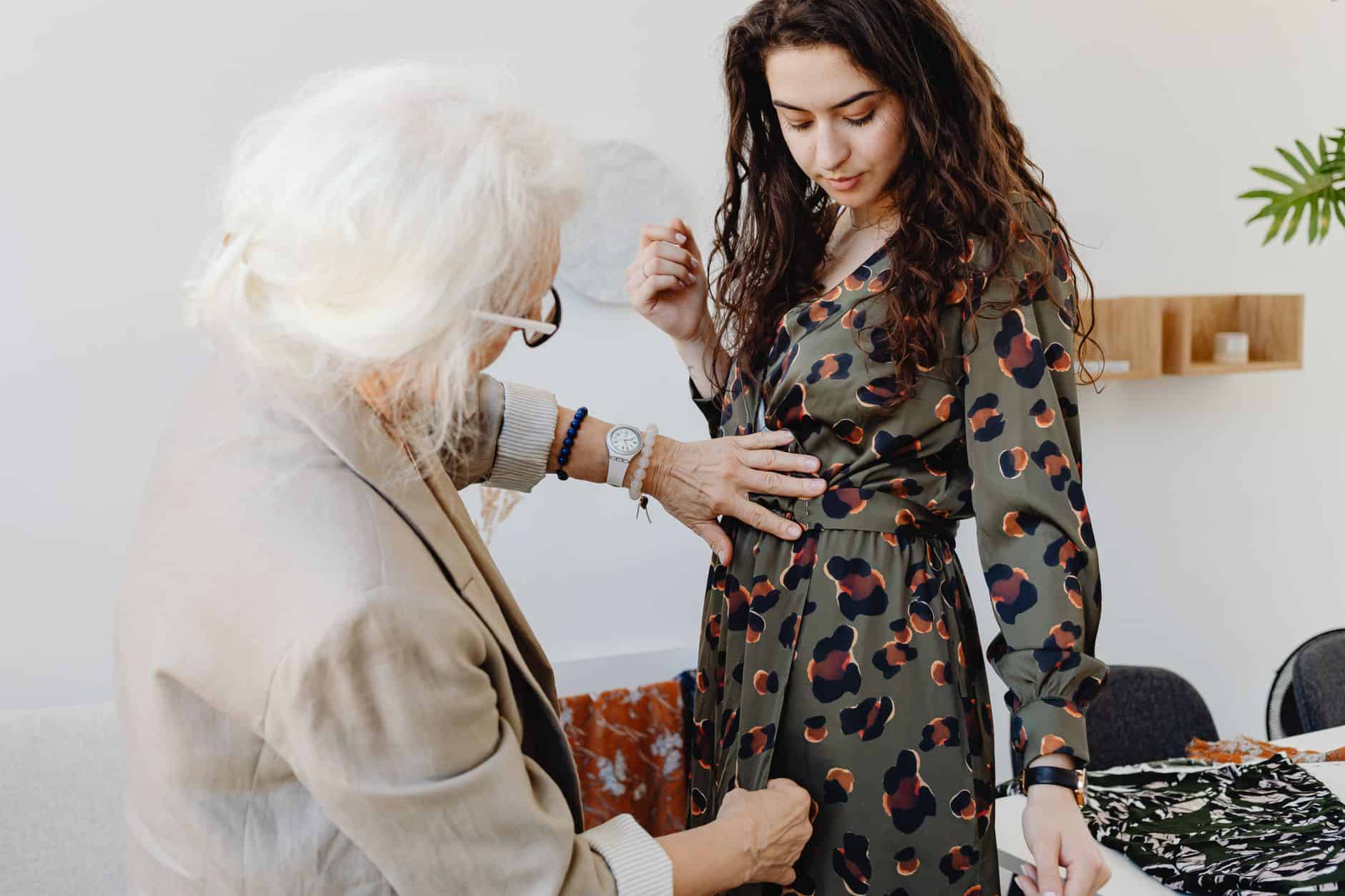 Grandmother adjusting a younger woman's dress