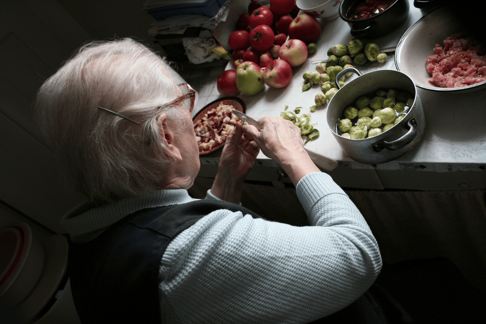 Grandmother preparing fresh vegetables at her kitchen counter