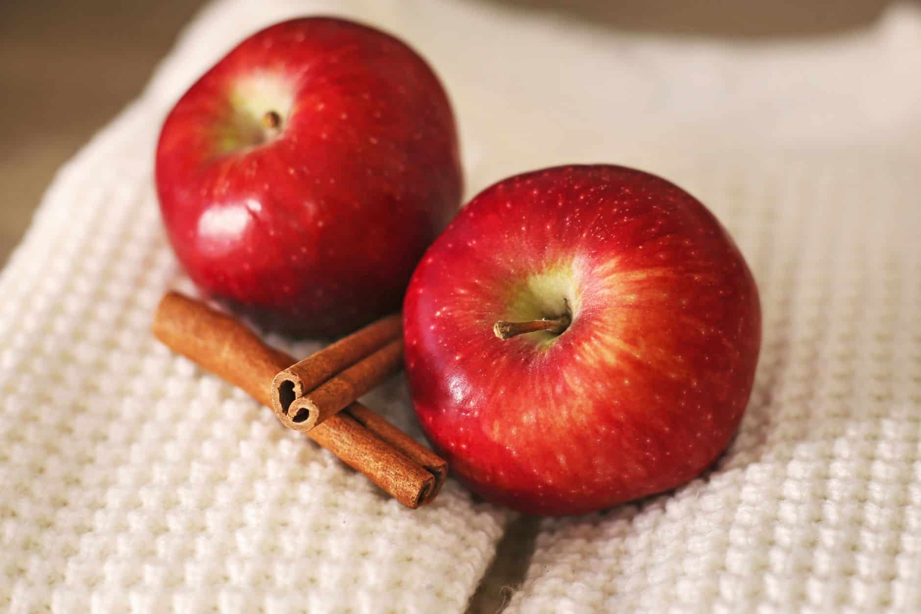 Red apples and cinnamon sticks for hot spiced cider