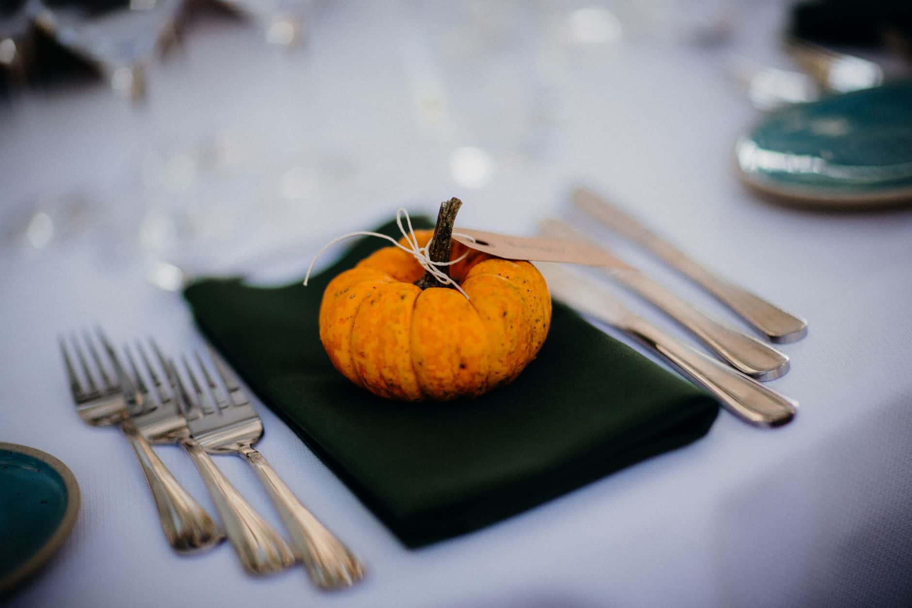 Autumn table setting with silverware and a mini pumpkin